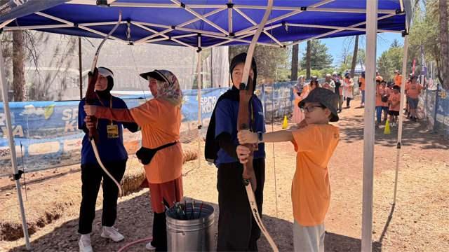 Konya Büyükşehir Belediyesinin Anne-Oğul Kampı etkinliğinde oğluyla beraber ok atan bir anne