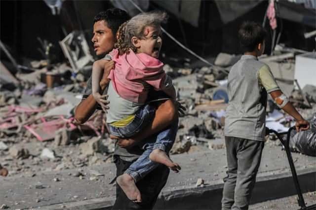 Gazzedeki insani krizin fotoğraflara yansımış hali, küçük bir çocuğu kucaklayarak savaşın ortasından uzaklaştıran bir ağabey