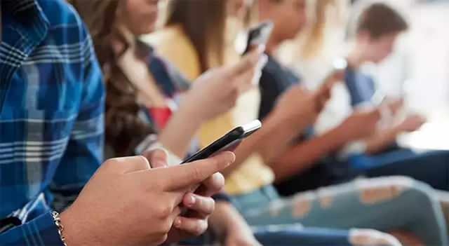 Ellerinde telefon ile sosyal medya da takılan bir grup kişi