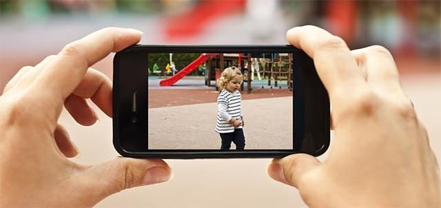 Çocuğu parkta oynarken onu videoya alan bir anne