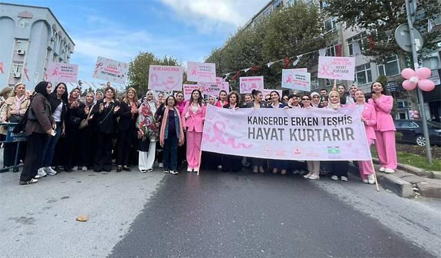 Kanserde erken teşhis hayat kurtarır yazılı pankartın önünde fotoğraf çekilen katılımcılar