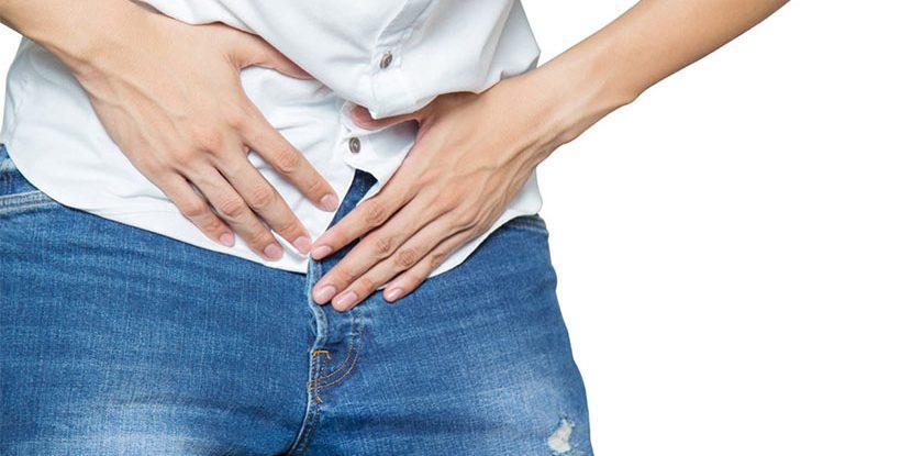 Kasık bölgesinde ağrı hisseden bir kişi