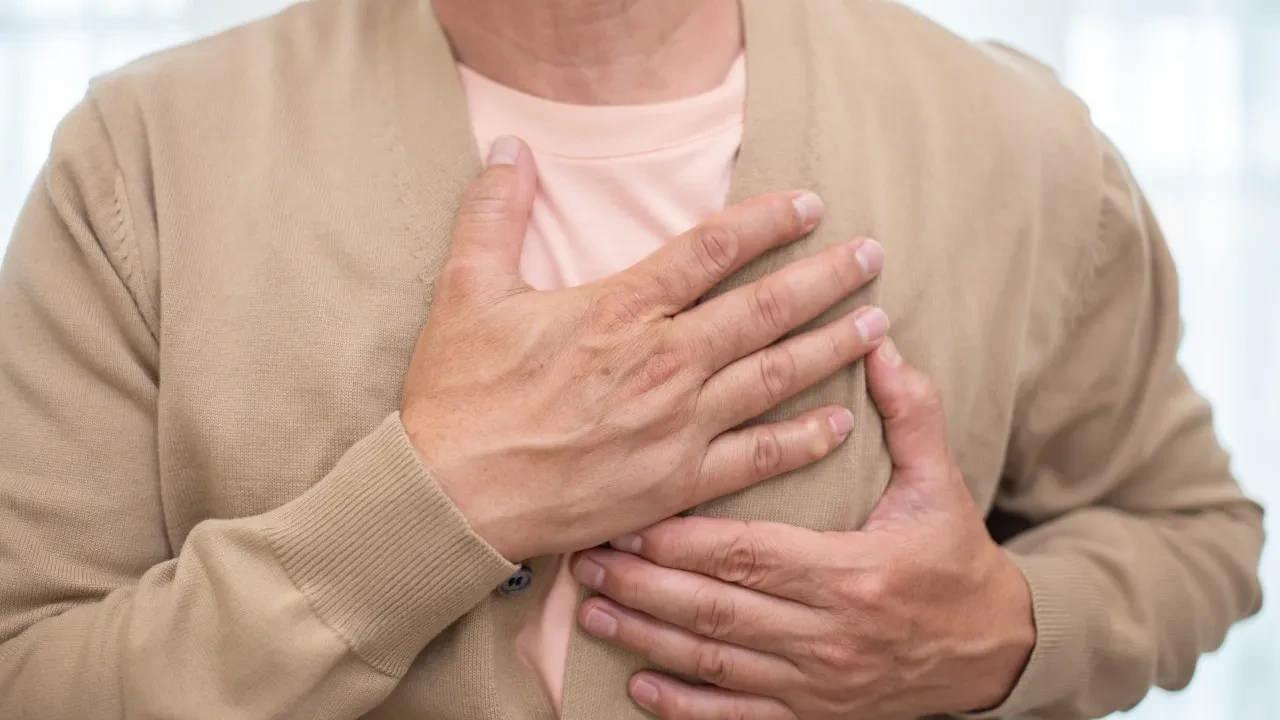 Kalp ağrısı çektiği için kalbini tutan bir kişi