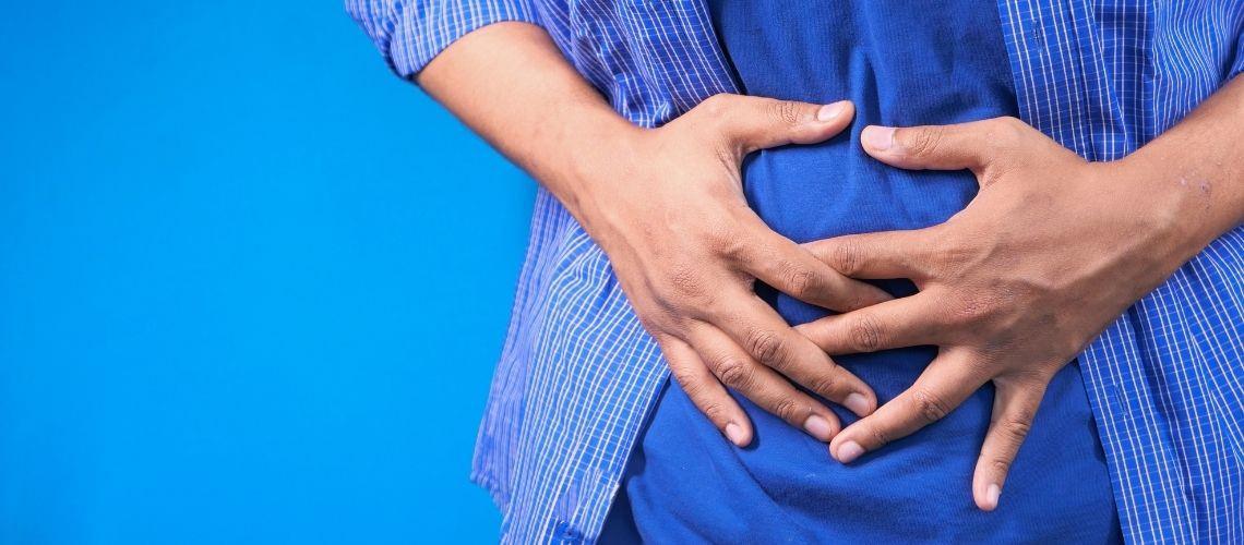 Karın bölgesini tutan bir erkek