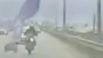 K&ouml;pr&uuml;den sarkan reklam afişi motosikletliyi yola savurdu